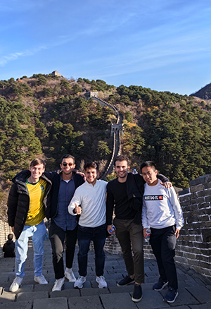 Students taking a group photo on the Great Wall of China during their business trip.