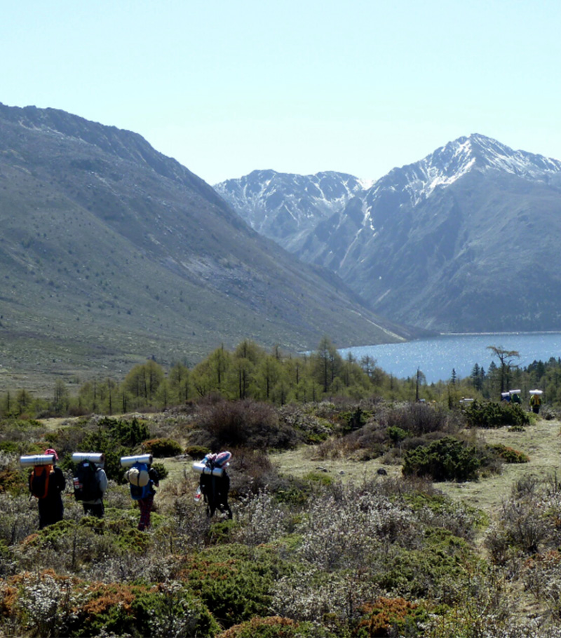 Students trekking through a forested mountain area in Kangding, Sichuan.