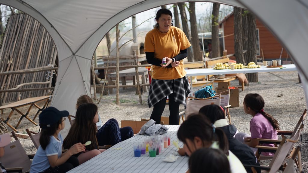 School trip leader guiding students on a camping residential in China.