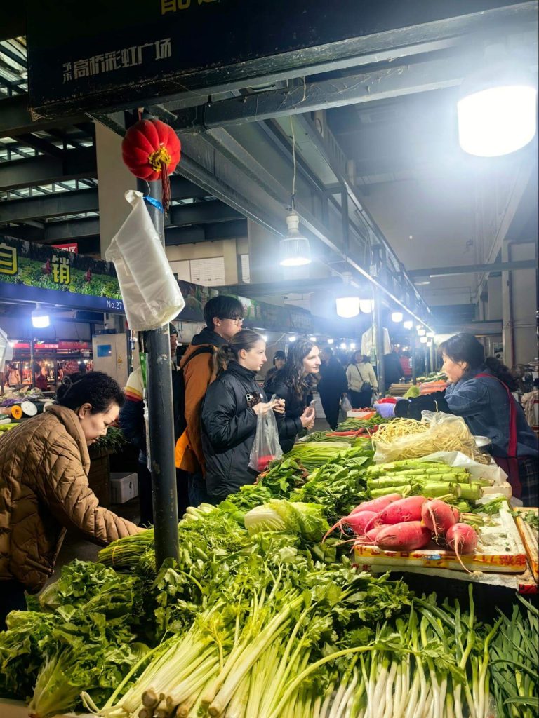 Students interacting with market traders using Mandarin in a scavenger hunt activity