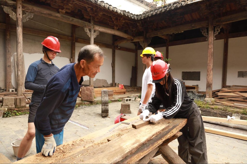 Students speaking with local community members in China during a school travel program.
